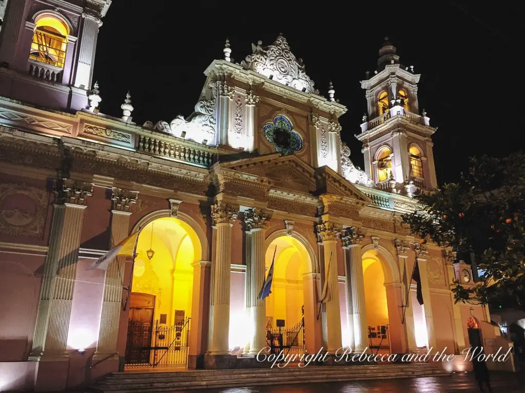 A historic church in Salta, Argentina, illuminated at night, showcasing its intricate architecture, with warm lighting accentuating its features.